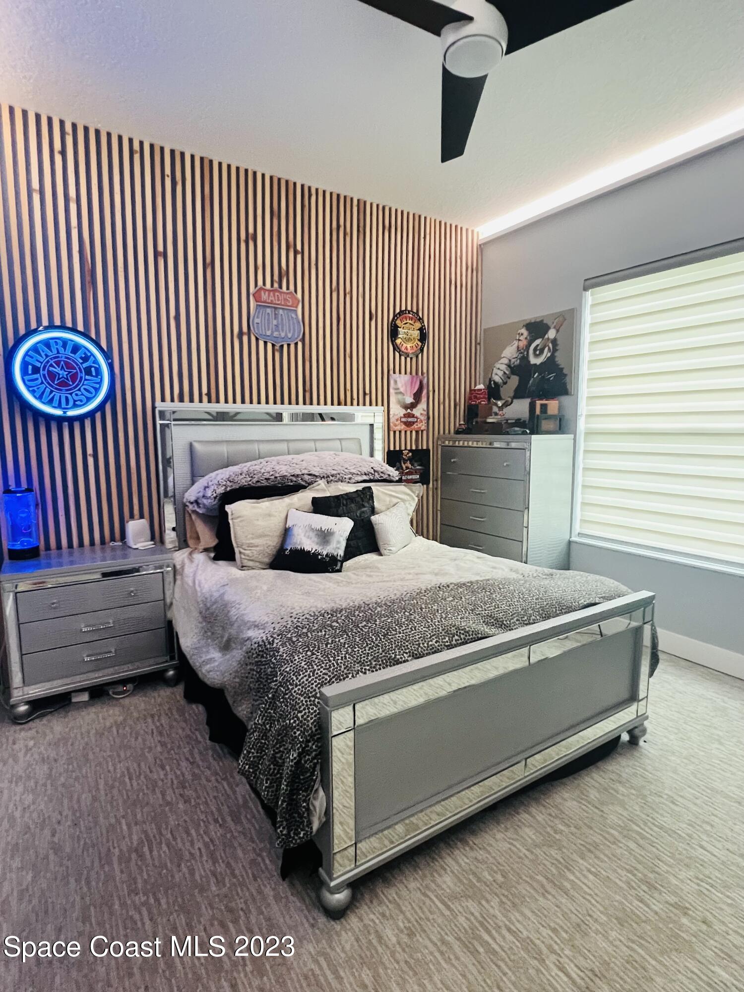 3231 Windsor Estates Drive Melbourne, FL 32940 - Photo 26 of 40 a bedroom with a bed and a chandelier