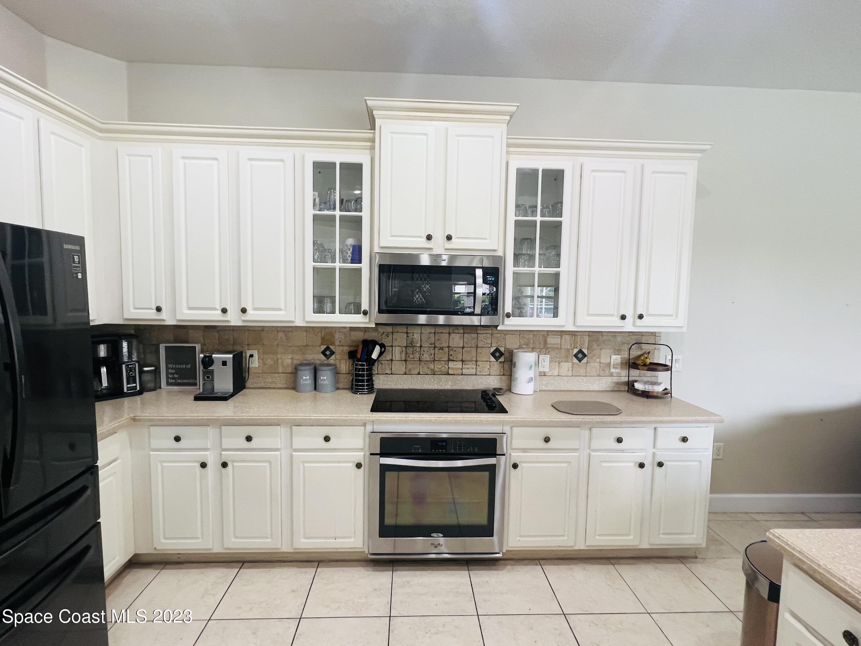 3231 Windsor Estates Drive Melbourne, FL 32940 - Photo 31 of 40 a kitchen with white cabinets and appliances