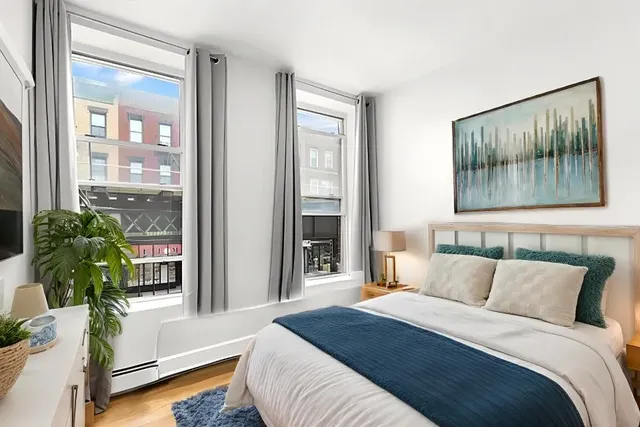 a bedroom with a bed and a potted plant