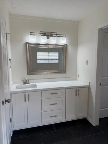 a sink with white cabinets