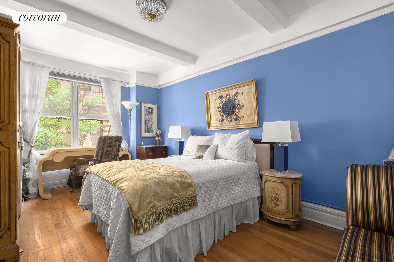 225 East 79th Street, Unit 2D Manhattan, NY 10075 - Photo 4 of 11 a bedroom with a bed a couch and large window