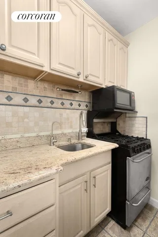 a kitchen with granite countertop white cabinets and a stove