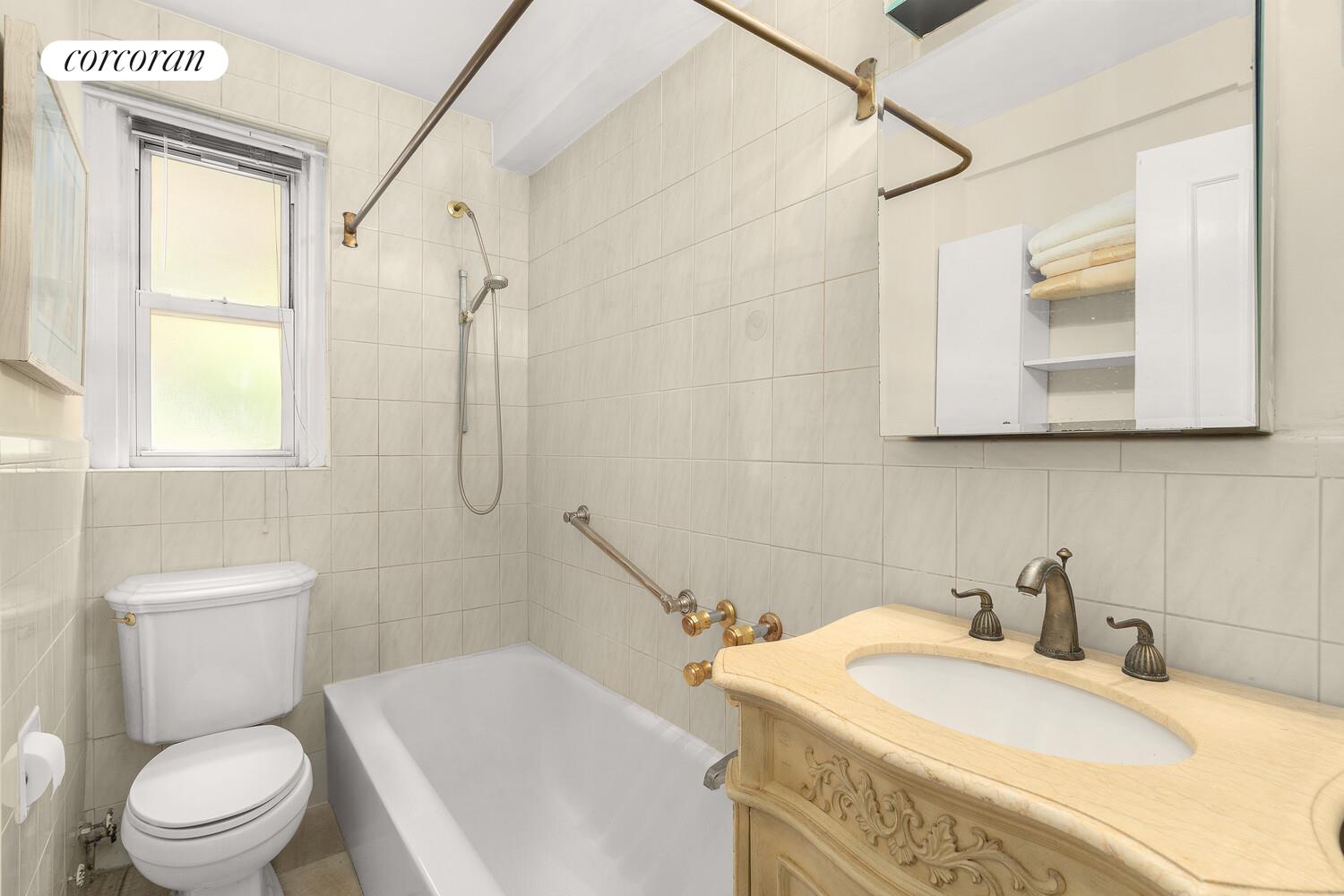 225 East 79th Street, Unit 2D Manhattan, NY 10075 - Photo 6 of 11 a bathroom with a sink a toilet and shower