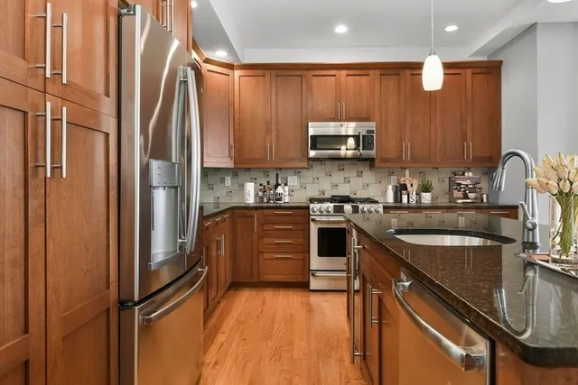 a kitchen with stainless steel appliances granite countertop a refrigerator sink and stove