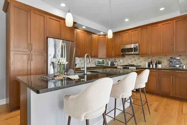 a kitchen with kitchen island granite countertop a sink counter top space appliances and cabinets