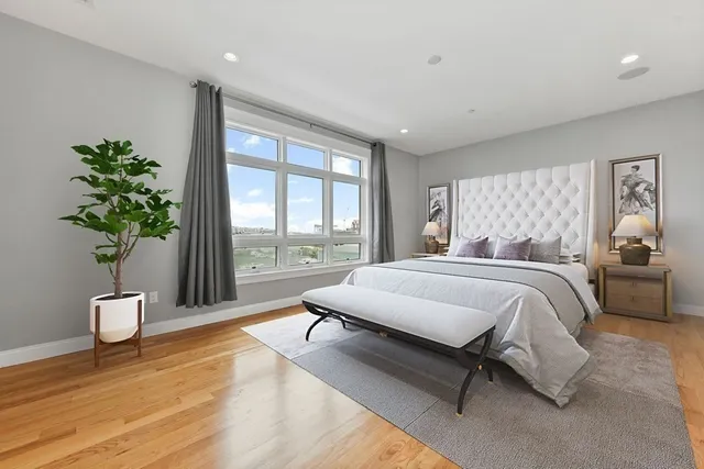 a spacious bedroom with a bed and a potted plant