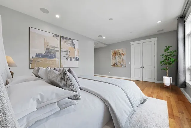 a bed room with a large bed and a potted plant