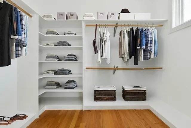 a view of walk in closet with clothes and shoes