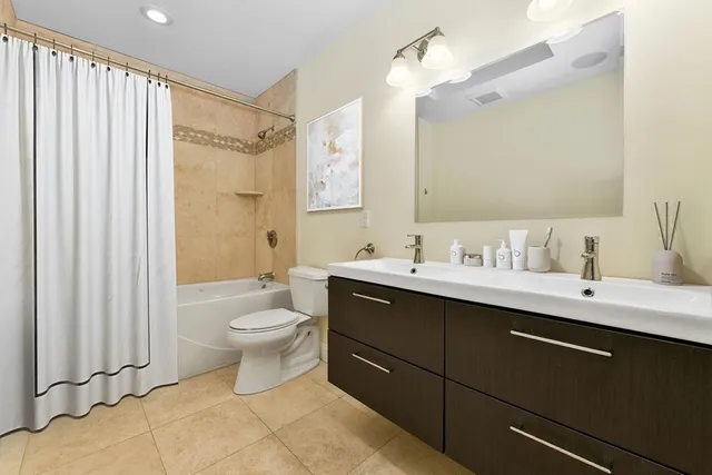 a bathroom with a double vanity sink mirror and toilet