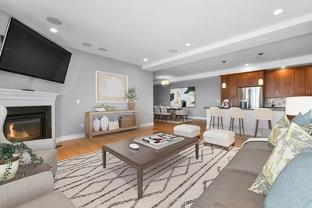 a living room with furniture a flat screen tv and a fireplace