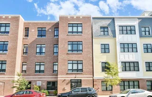 a front view of a residential apartment building with a yard