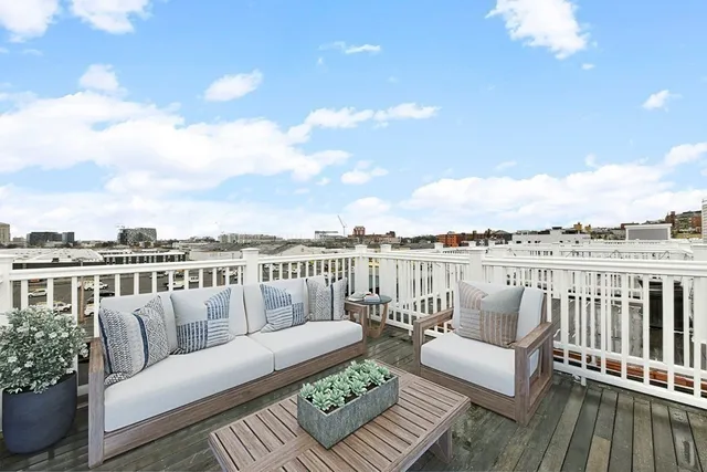 a balcony with wooden floor and city view