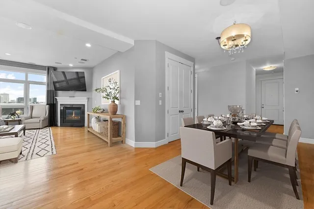 a dining room with furniture a chandelier and wooden floor
