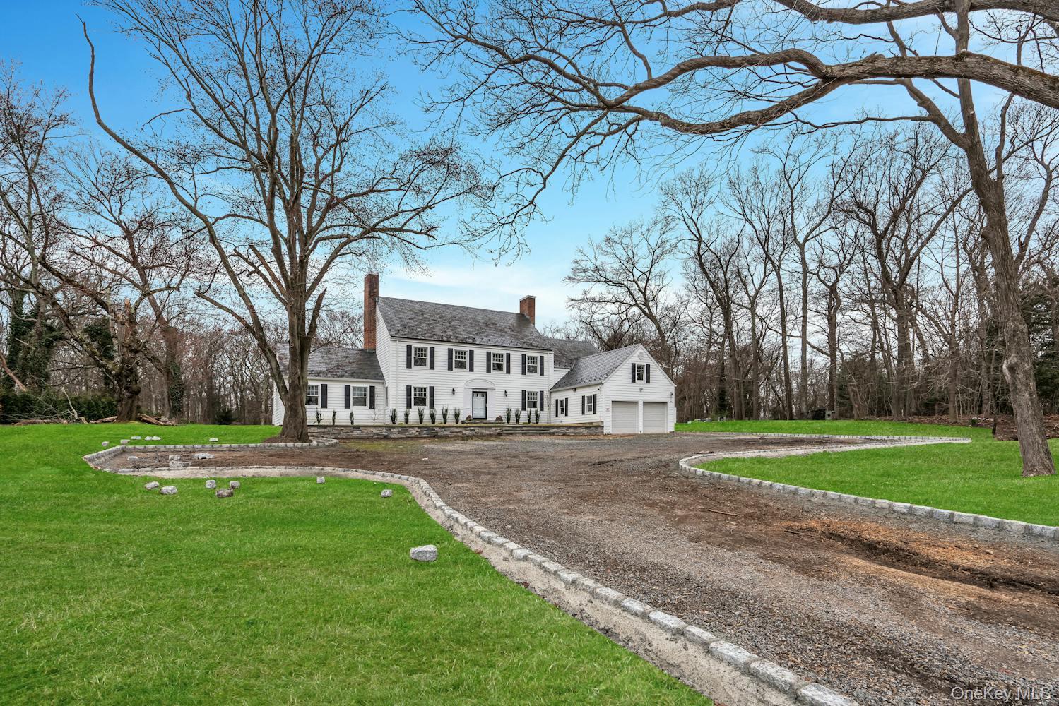 539 Split Rock Road Syosset, NY 11791 - Photo 39 of 40 Colonial-style house featuring a garage, a chimney, a front lawn, and dirt driveway