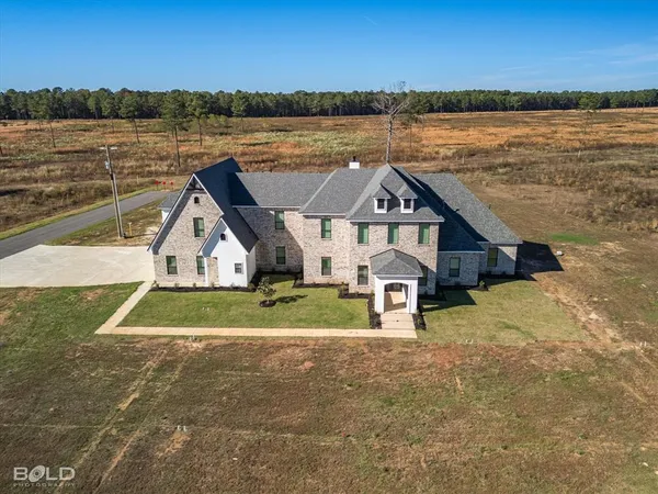 a front view of a house with a yard and lake view