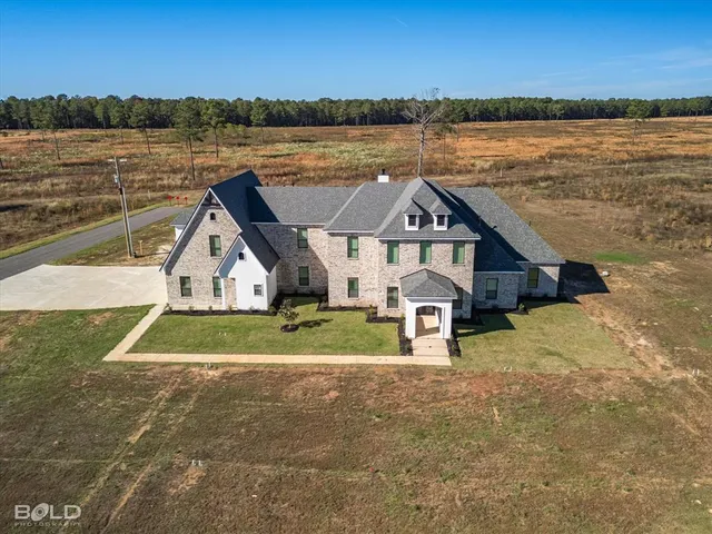 a front view of a house with a yard and lake view