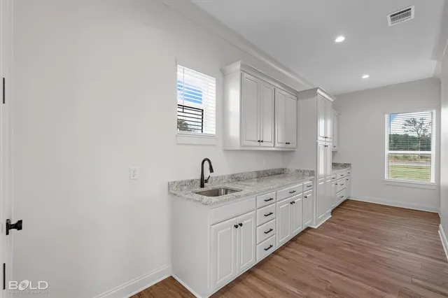 a kitchen with a sink window and cabinets