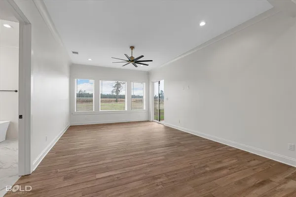 a view of an empty room with a window and wooden floor