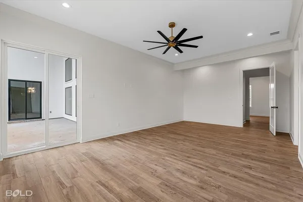 a view of a big room with wooden floor and windows