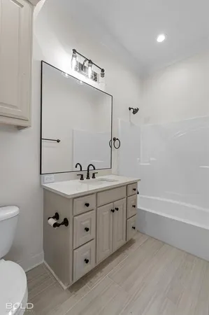 a bathroom with a double vanity sink mirror and toilet