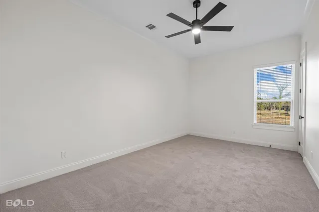 an empty room with a window and a fan