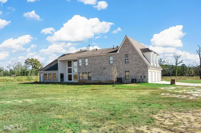 a view of a house with a yard and sitting area