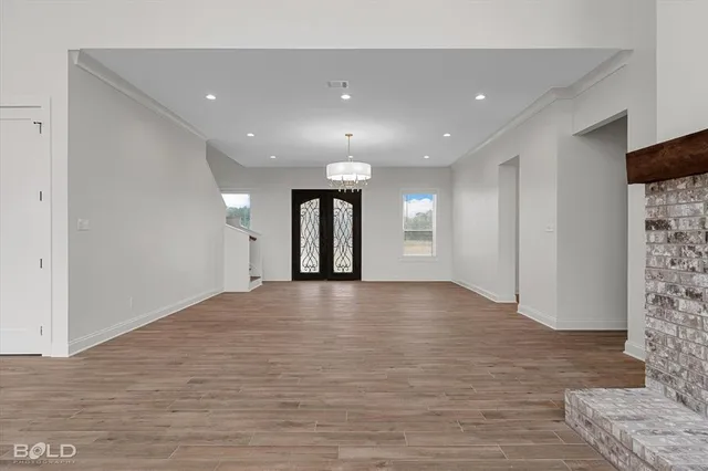 a view of an empty room with wooden floor and entryway