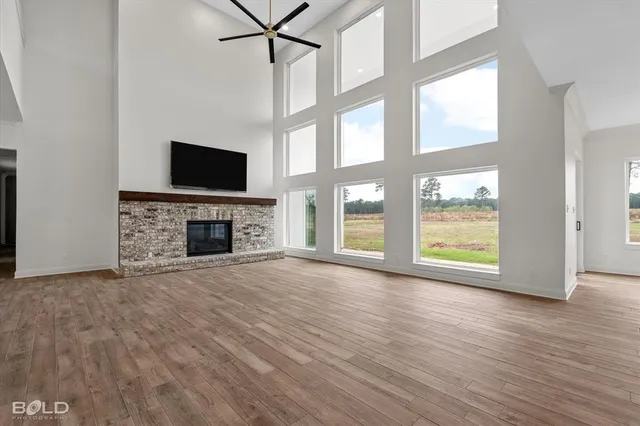 a view of empty room with fireplace and wooden floor