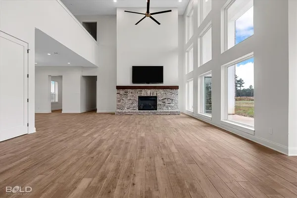 wooden floor fireplace and windows in an empty room