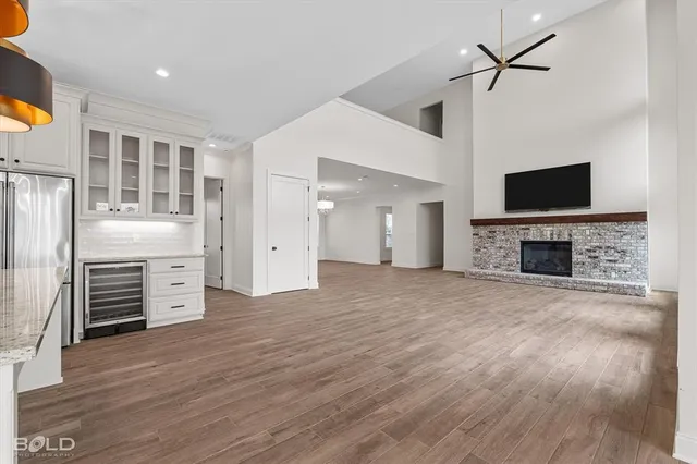 an empty room with furniture a flat screen tv and a fireplace