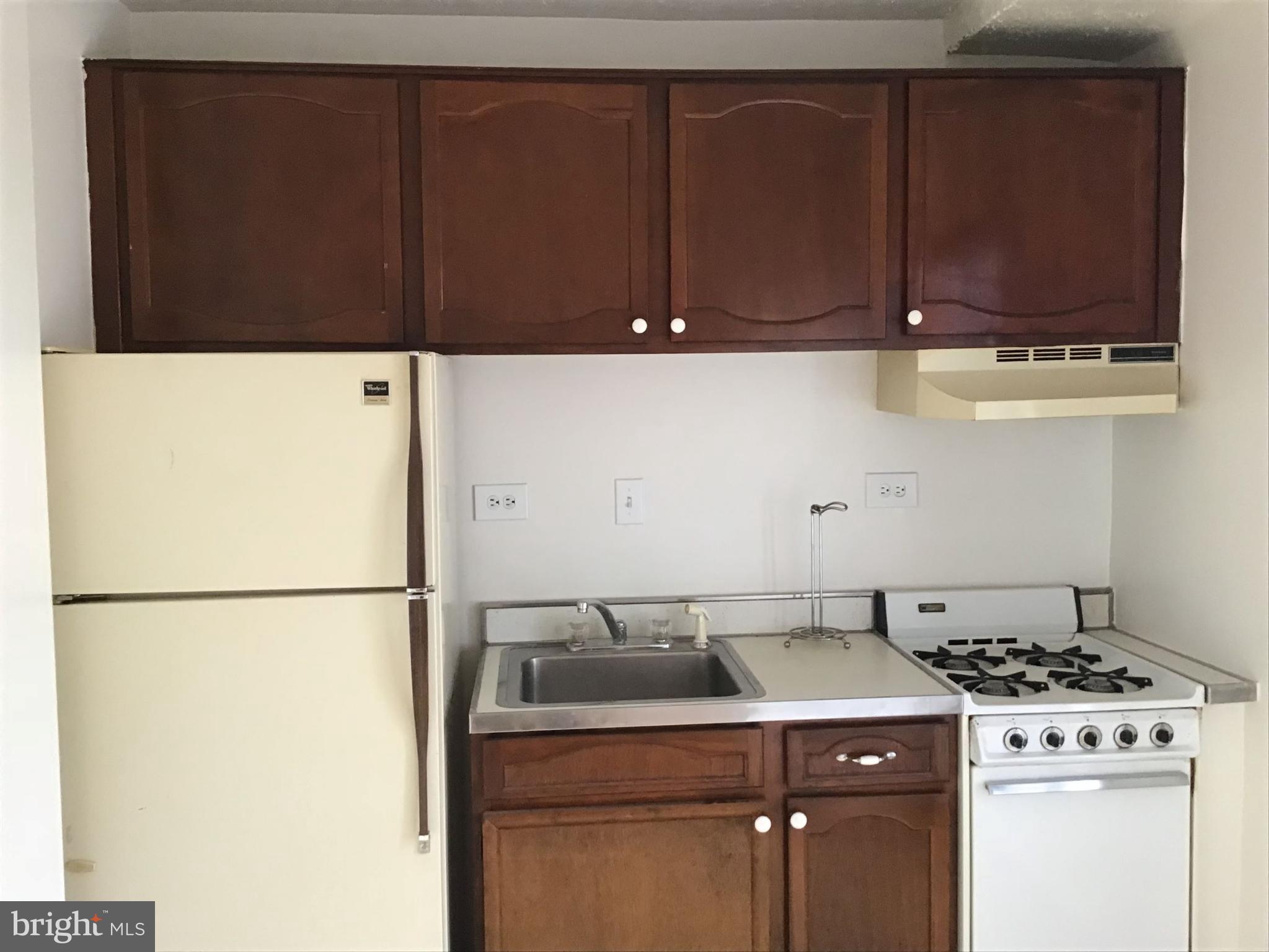 1440 N Street Northwest, Unit 812 Washington, DC 20005 - Photo 4 of 23 a kitchen with a refrigerator and cabinets