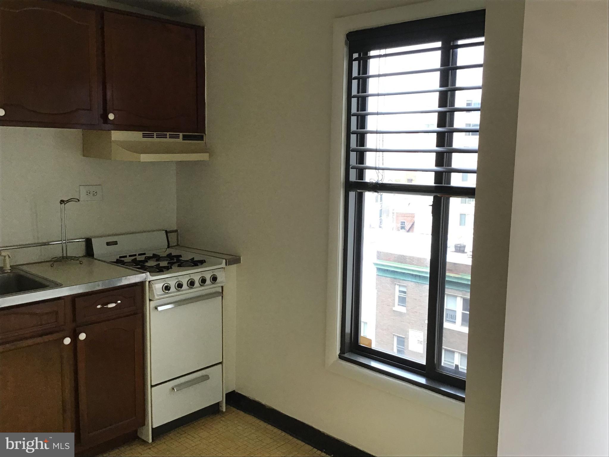 1440 N Street Northwest, Unit 812 Washington, DC 20005 - Photo 5 of 23 a kitchen with a stove and a window