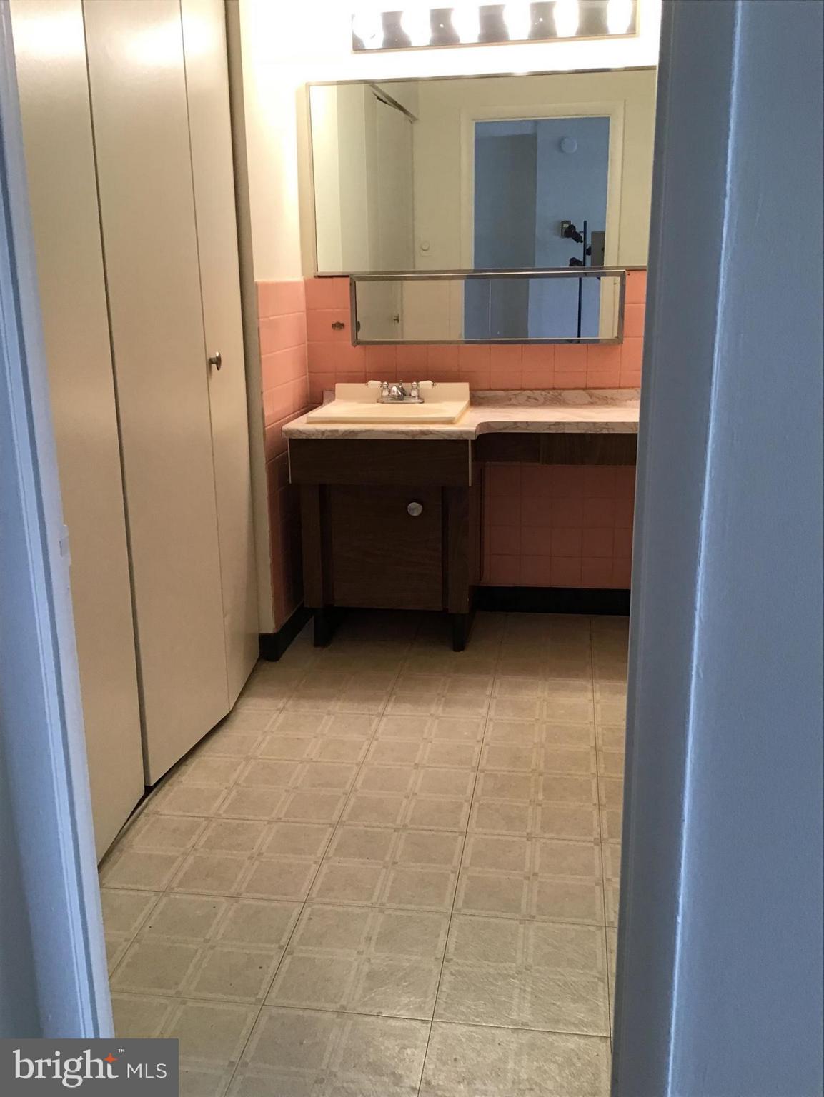 1440 N Street Northwest, Unit 812 Washington, DC 20005 - Photo 6 of 23 a bathroom with a sink a mirror and a bathtub