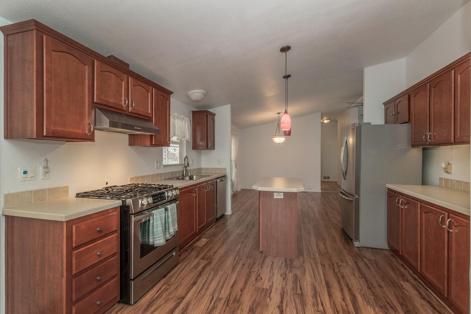 a kitchen with stainless steel appliances granite countertop wooden floors and stove