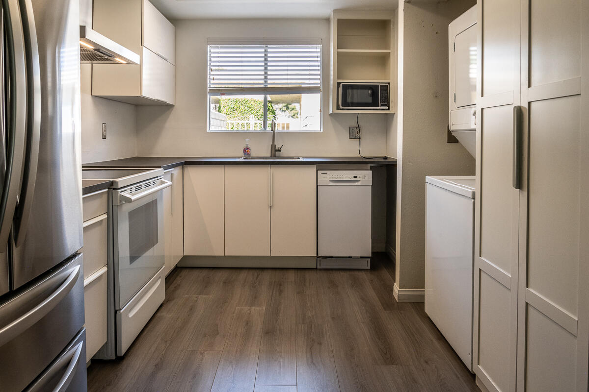 48941 Eisenhower Drive Indio, CA 92201 - Photo 6 of 17 a kitchen with white cabinets and wooden floor