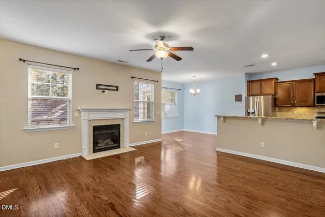 a view of empty room with wooden floor fireplace and a window