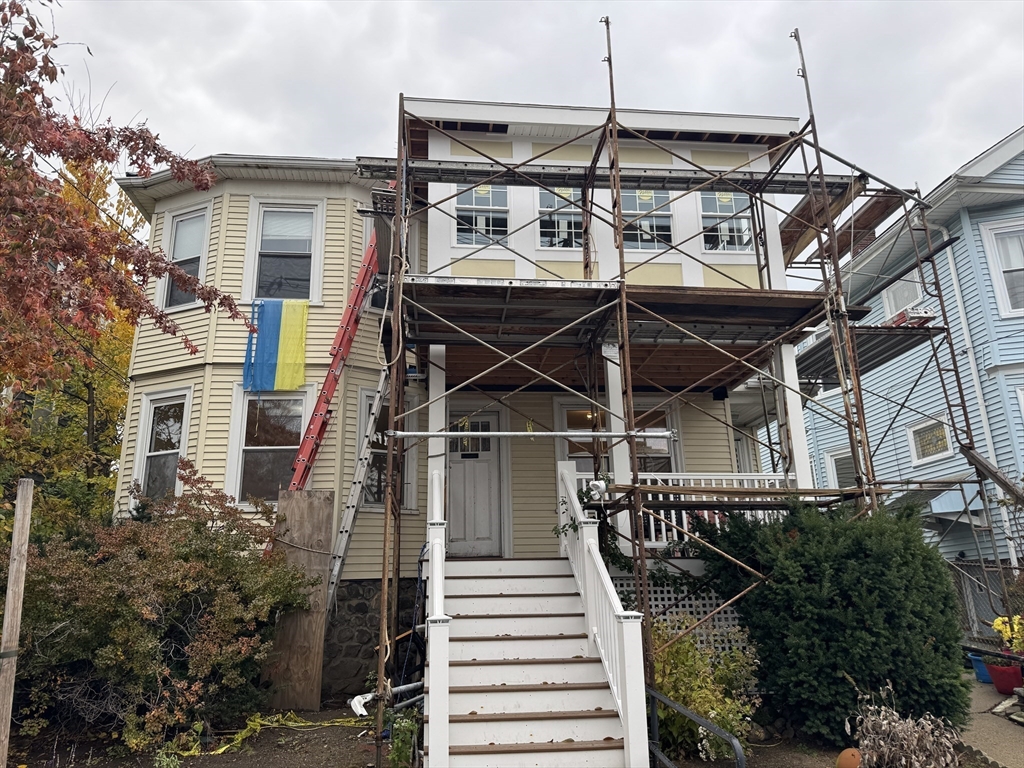 71-73 Turner Street, Unit 73 Boston, MA 02135 - Photo 14 of 14 a view of a white house with a small yard and potted plants