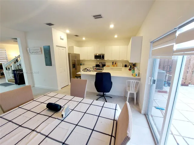 a kitchen with stainless steel appliances kitchen island granite countertop a refrigerator and a stove top oven