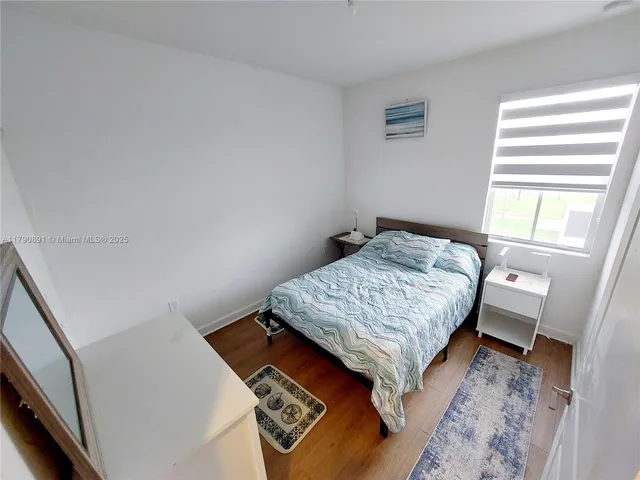 a bedroom with a bed lamp and a window