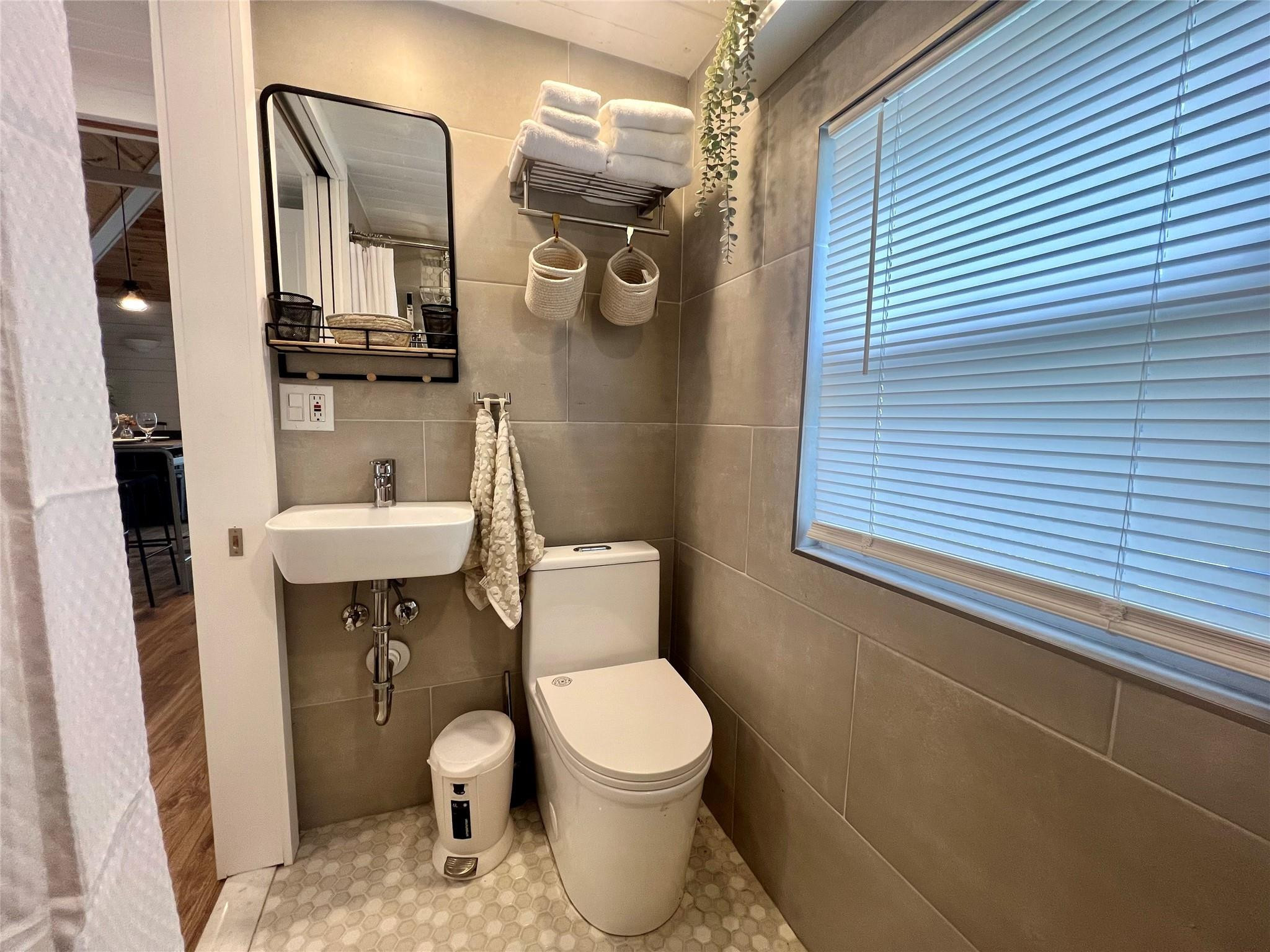 12 Southwest 6th Street Delray Beach, FL 33444 - Photo 6 of 9 a bathroom with a toilet a sink and mirror