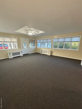 an empty room with a fireplace and large window