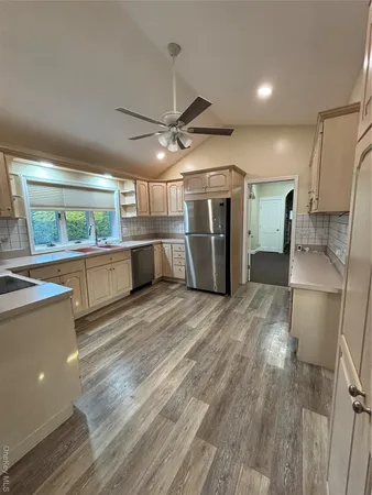 a view of a kitchen with a sink and a refrigerator