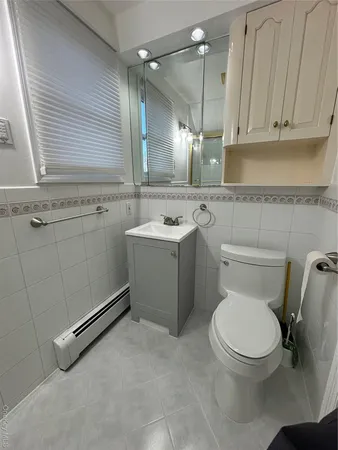 a bathroom with a toilet sink and mirror