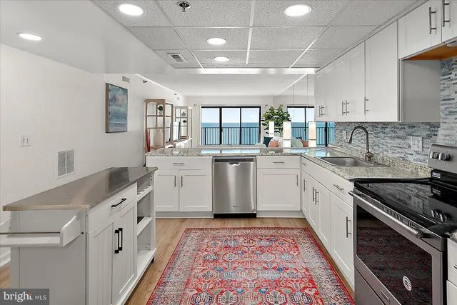 a kitchen with white cabinets and sink