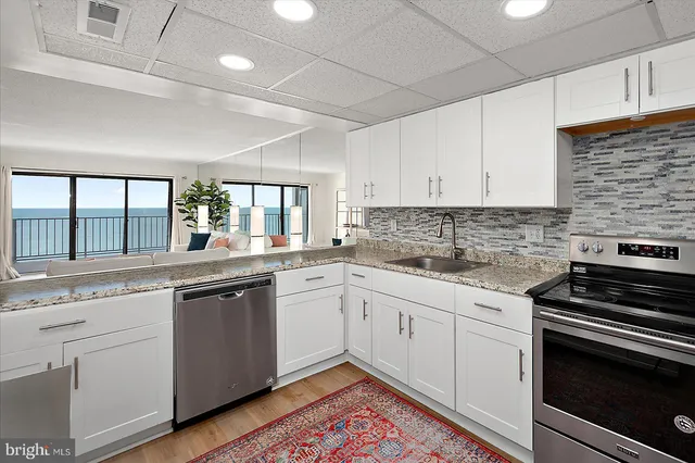 a kitchen with stainless steel appliances granite countertop dining table chairs and a refrigerator