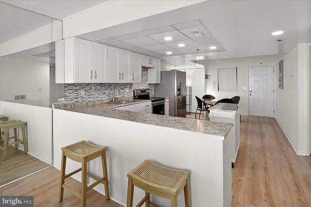 a kitchen with stainless steel appliances granite countertop a refrigerator and a stove top oven