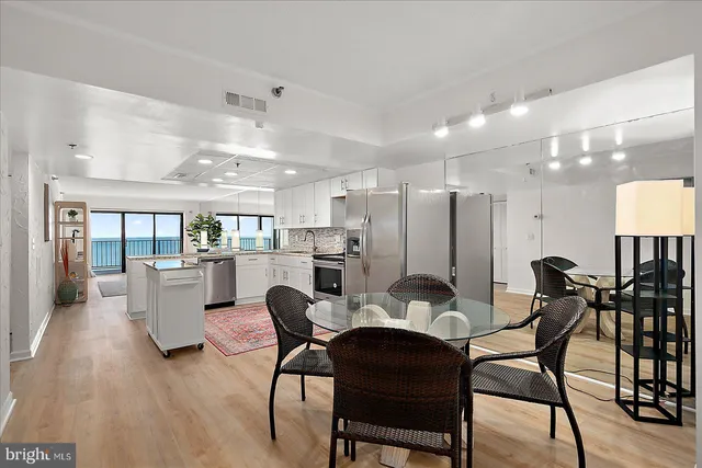 a view of a dining room with furniture and a refrigerator