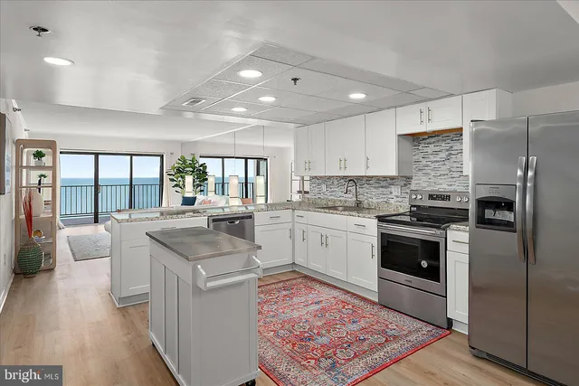 a living room with furniture large windows and wooden floor