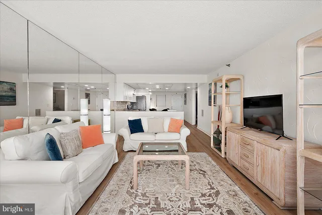 a living room with furniture and a view of kitchen