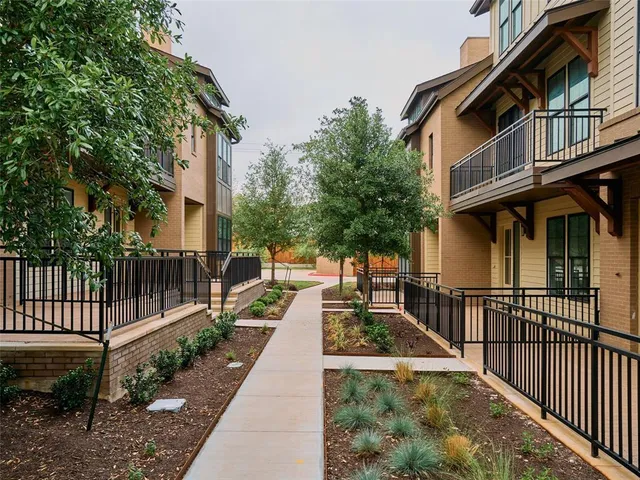 a view of a brick house with a large window and wooden fence
